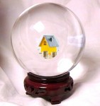 Crystal ball with miniature yellow house inside.