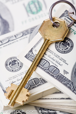 Golden key on stacked dollar bills.