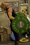 Person lifting a heavy barbell indoors.