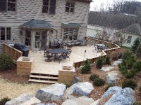 Wooden deck and garden with stone path.