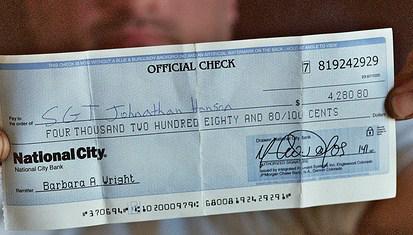 A person holding an official bank check.