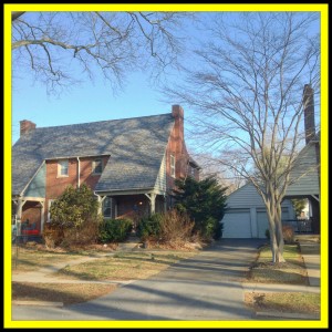 Brick house with trees in front yard.