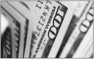 Close-up of hundred-dollar bills in grayscale.